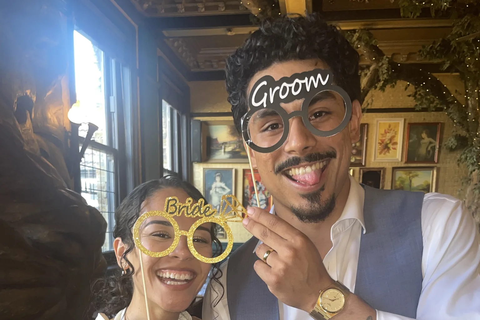 Newlyweds posing together with playful wedding glasses